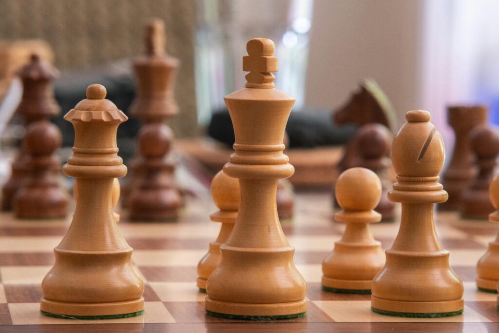 A detailed view of wooden chess pieces positioned on a chessboard.